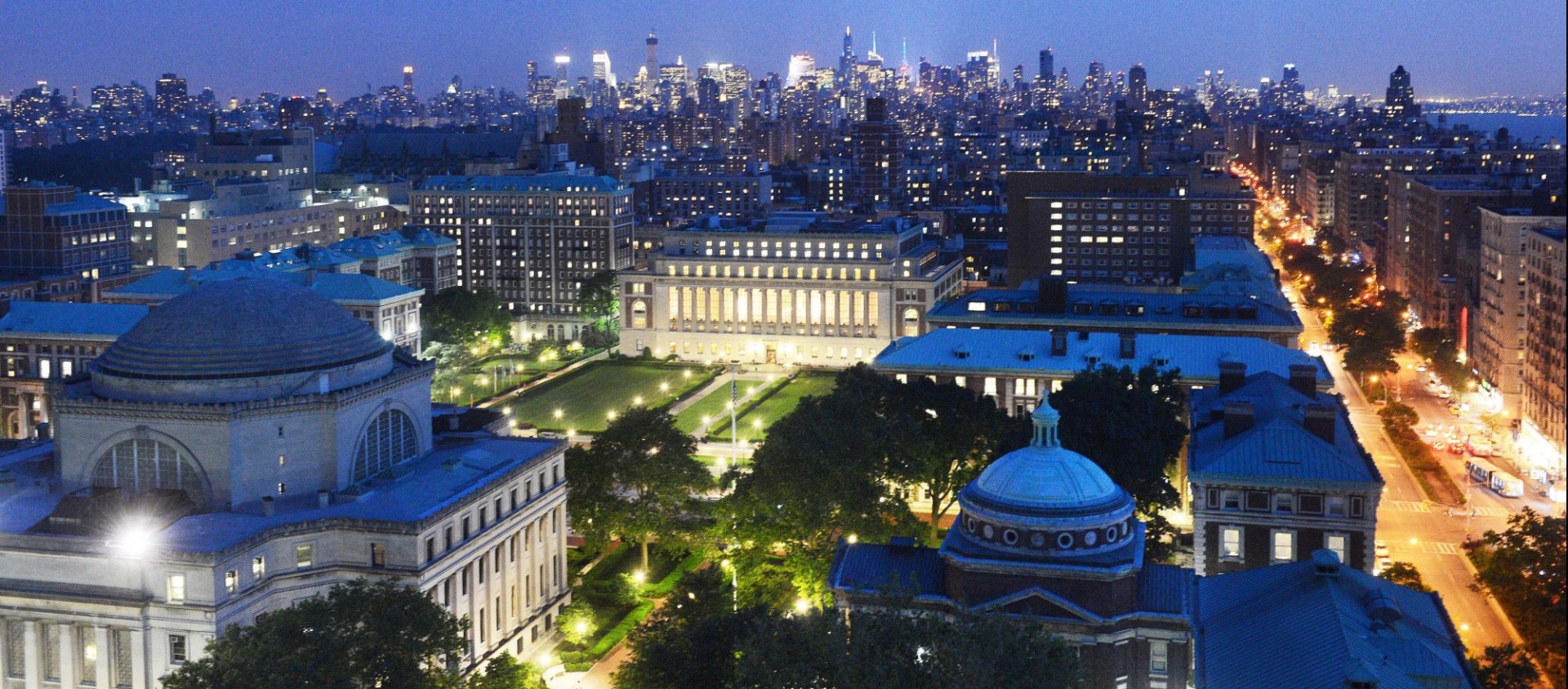 Aerial view of Morningside campus at dusk with Low Library and other buildings lit up