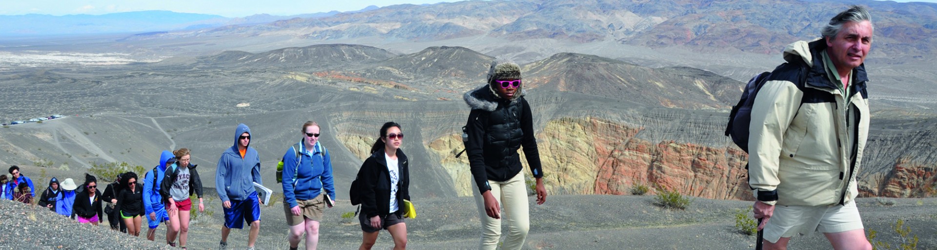 Group of students and professor hiking through mountains