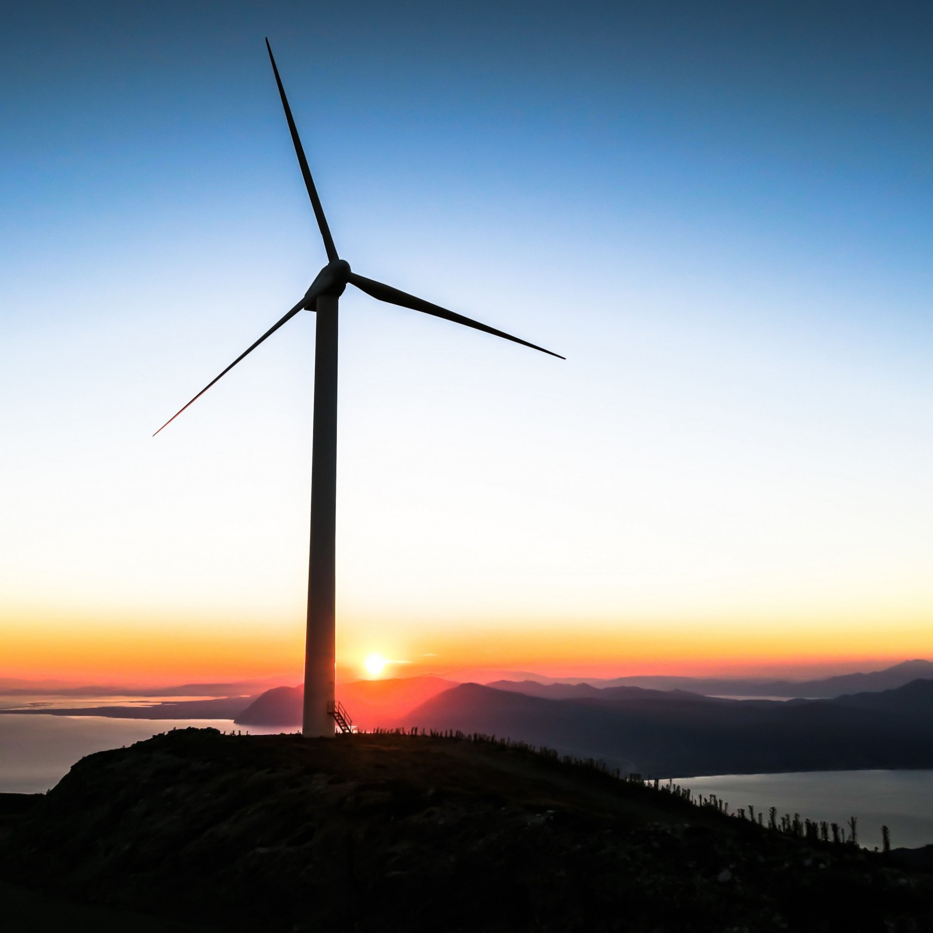 Wind turbine on a hill at sunset