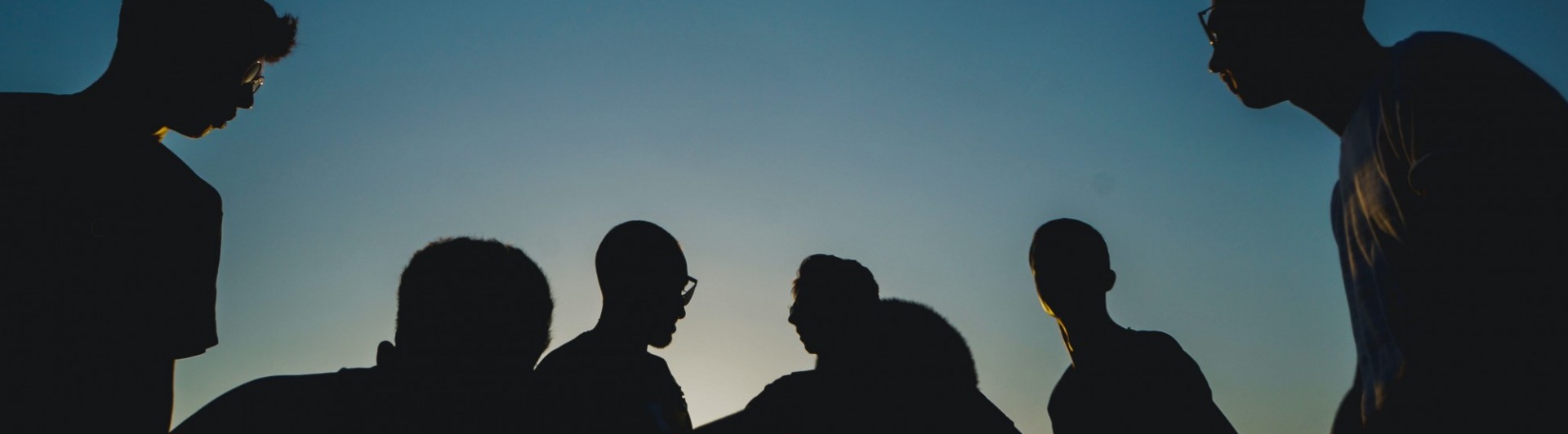 Group of people in silhouette against blue sky
